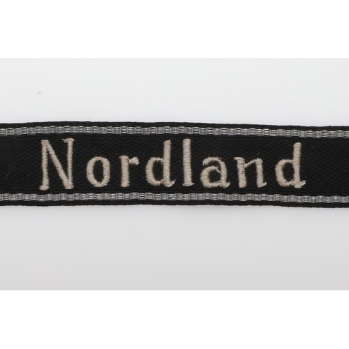 244 - A SECOND WORLD WAR GERMAN 'NORDLAND' CUFF TITLE. A machine embroidered cuff title 'Nordland' in whit... 