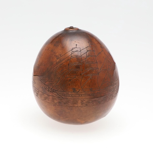 311 - AN UNUSUAL AMERICAN HAWAIIAN NAUTICAL CARVED TROPICAL NUT. An incised tropical nut with a three mast... 