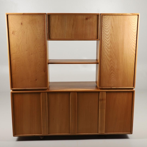 668 - ERCOL ELM SIDEBOARD/DISPLAY CABINET. From the Windsor range, a light elm side sideboard with three c... 