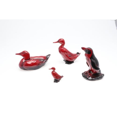 700 - THREE ROYAL DOULTON FLAMBE DUCKS & A PENGUIN. Including a swimming duck, 20cm long, a mallard, 15cm ... 