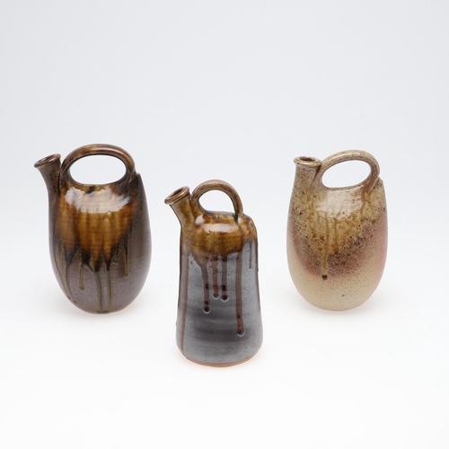 704 - JOHN LEACH (1939-2021) - THREE STONEWARE STUDIO POTTERY FLAGONS. Each of sack form, and with a parti... 