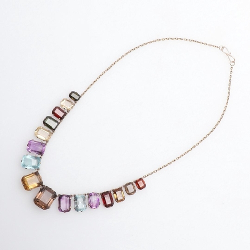 1009 - A GOLD AND GEM SET NECKLACE. formed with graduated rectangular-shaped gem stones, including aquamari... 