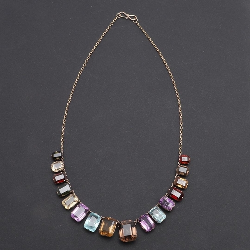 1009 - A GOLD AND GEM SET NECKLACE. formed with graduated rectangular-shaped gem stones, including aquamari... 