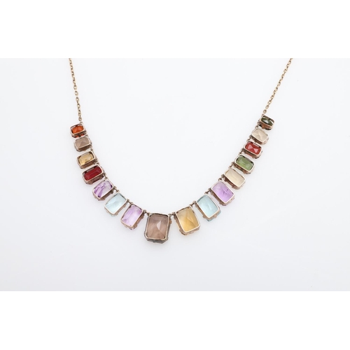 1009 - A GOLD AND GEM SET NECKLACE. formed with graduated rectangular-shaped gem stones, including aquamari... 