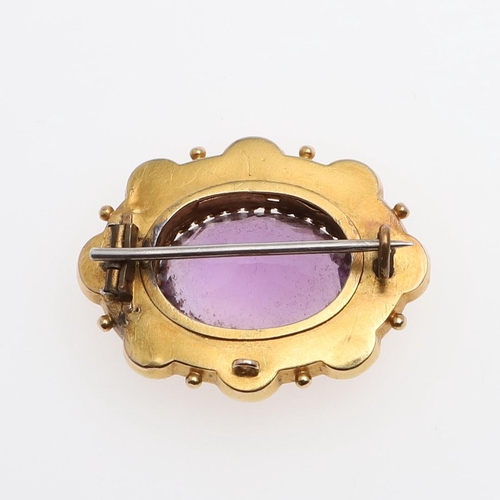 1011 - AN AMETHYST AND GOLD BROOCH. the oval-shaped amethyst is set within an ornate gold mount set with sm... 