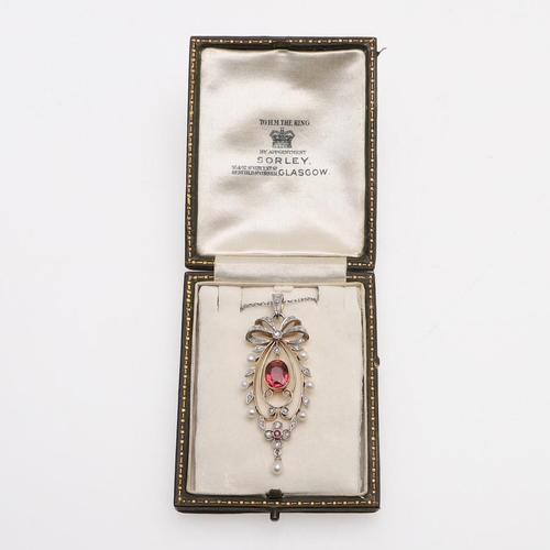 1022 - AN EDWARDIAN TOURMALINE, DIAMOND AND PEARL PENDANT. the oval-shaped red tourmaline is set within a f... 