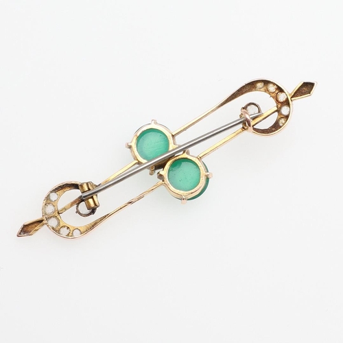 1027 - A CHRYSOPRASE AND GOLD BROOCH. the scrolling openwork mount is centred with two chrysoprase cabochon... 