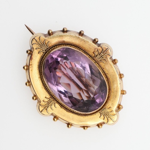 1029 - A VICTORIAN AMETHYST AND GOLD BROOCH. the oval-shaped amethyst is set within a gold mount with ball ... 