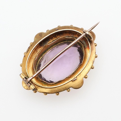 1029 - A VICTORIAN AMETHYST AND GOLD BROOCH. the oval-shaped amethyst is set within a gold mount with ball ... 