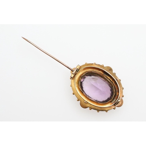 1029 - A VICTORIAN AMETHYST AND GOLD BROOCH. the oval-shaped amethyst is set within a gold mount with ball ... 