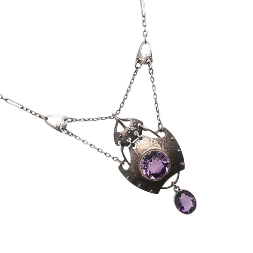 1031 - AN ART NOUVEAU AMETHYST AND SILVER PENDANT BY MURRLE BENNETT & CO. the hammered silver mount is cent... 