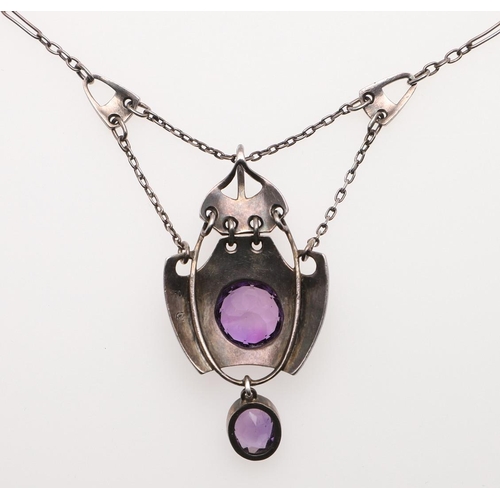 1031 - AN ART NOUVEAU AMETHYST AND SILVER PENDANT BY MURRLE BENNETT & CO. the hammered silver mount is cent... 