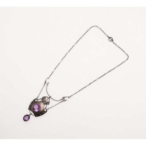 1031 - AN ART NOUVEAU AMETHYST AND SILVER PENDANT BY MURRLE BENNETT & CO. the hammered silver mount is cent... 