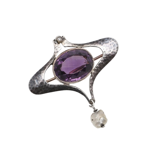 1032 - A SILVER AND AMETHYST BROOCH BY MURRLE BENNETT & CO. the silver hammered mount is centred with an ov... 