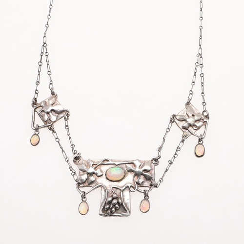 1035 - AN ARTS AND CRAFTS SILVER AND OPAL NECKLACE. the silver panels with applied fruiting vine decoration... 