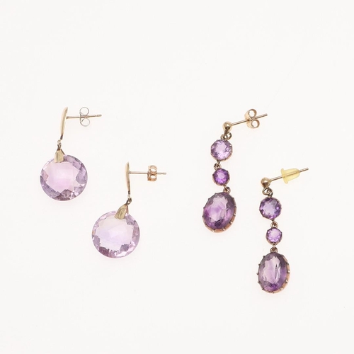 1038 - A PAIR OF AMETHYST DROP EARRINGS. each earring mounted with an oval-shaped amethyst drop suspended f... 