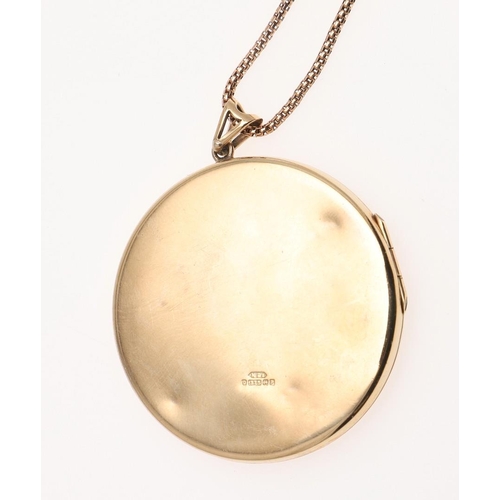 1040 - A 9CT GOLD CIRCULAR LOCKET PENDANT. with foliate engraved decoration to the front, 4.2cm dia., on a ... 