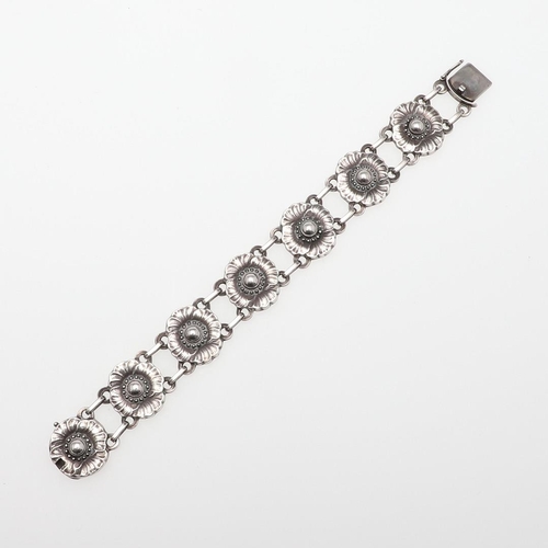 1064 - A SILVER FOLIATE BRACELET BY GEORG JENSEN. formed with seven flowerhead links, with concealed clasp,... 