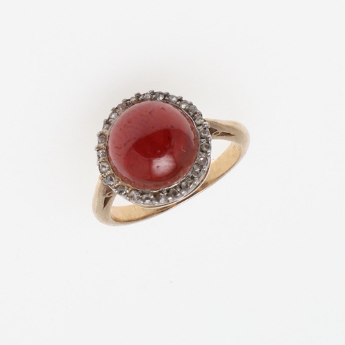 1069 - AN ANTIQUE GARNET AND DIAMOND CLUSTER RING. the circular cabochon garnet is set within a surround of... 