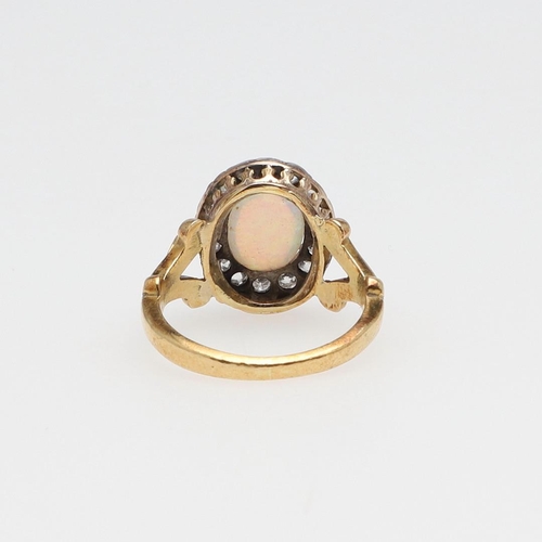 1070 - AN OPAL AND DIAMOND CLUSTER RING. the oval-shaped solid white opal is set within a surround of old-c... 