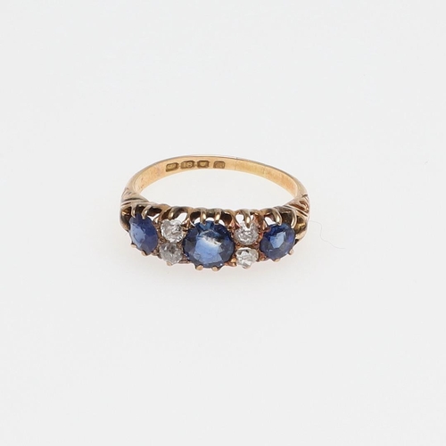 1073 - AN ANTIQUE SAPPHIRE AND DIAMOND RING. the three graduated circular-cut sapphires are set with four o... 