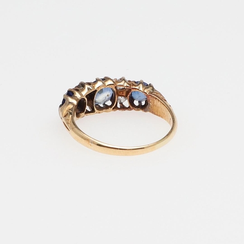 1073 - AN ANTIQUE SAPPHIRE AND DIAMOND RING. the three graduated circular-cut sapphires are set with four o... 