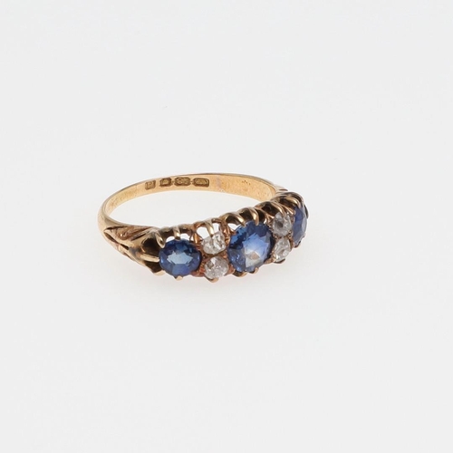 1073 - AN ANTIQUE SAPPHIRE AND DIAMOND RING. the three graduated circular-cut sapphires are set with four o... 