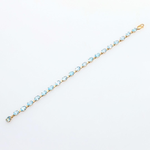 1077 - A BLUE TOPAZ AND GOLD BRACELET. formed with oval-shaped blue topazes in yellow gold, 18cm long, 5.0 ... 