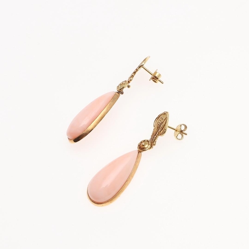 1095 - A PAIR OF CORAL AND GOLD DROP EARRINGS. each earring mounted with a pear-shaped coral drop suspended... 