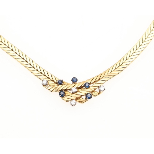 1099 - AN 18CT GOLD, SAPPHIRE AND DIAMOND NECKLACE. the herringbone neckace is mounted to the centre with c... 