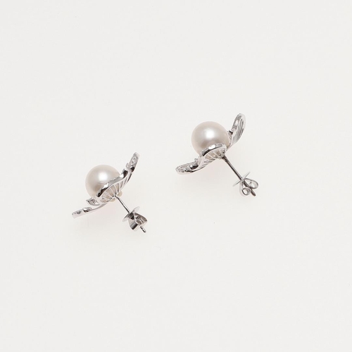 1104 - A PAIR OF CULTURED PEARL AND DIAMOND FLOWERHEAD EARRINGS. the cultured pearl set within four diamond... 