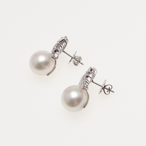 1106 - A PAIR OF CULTURED PEARL AND DIAMOND EARRINGS. the large cultured pearl surmounted by a spray of mar... 