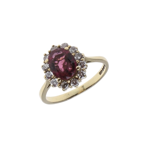 1118 - A PINK TOURMALINE AND DIAMOND CLUSTER RING. the oval-shaped pink tourmaline is set within a surround... 