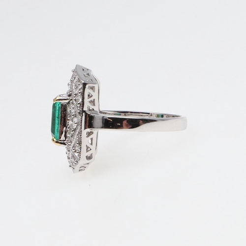 1119 - AN EMERALD AND DIAMOND CLUSTER RING. the cut-cornered rectangular-shaped emerald weighs approximatel... 