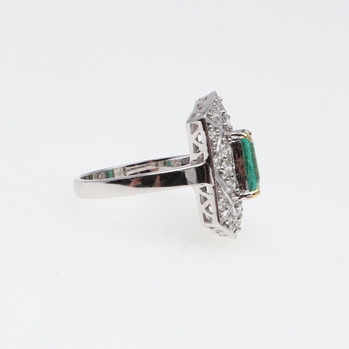 1119 - AN EMERALD AND DIAMOND CLUSTER RING. the cut-cornered rectangular-shaped emerald weighs approximatel... 