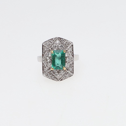 1119 - AN EMERALD AND DIAMOND CLUSTER RING. the cut-cornered rectangular-shaped emerald weighs approximatel... 