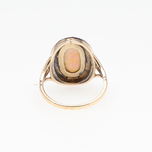 1124 - AN OPAL AND DIAMOND CLUSTER RING. the oval-shaped solid white opal is set within a surround of rose-... 