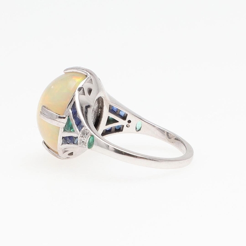 1127 - AN OPAL AND GEM SET RING. the oval-shaped solid white opal is set with two circular-cut diamonds and... 