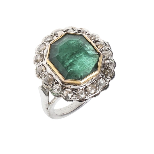 1132 - AN EMERALD AND DIAMOND CLUSTER RING. the octagonal-shaped emerald is set within a surround of circul... 