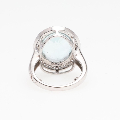 1133 - AN AQUAMARINE AND DIAMOND CLUSTER RING. the oval-shaped aquamarine is set within a surround of circu... 