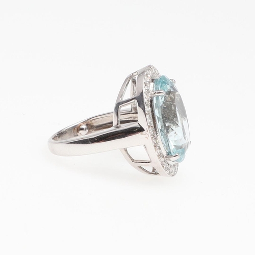 1133 - AN AQUAMARINE AND DIAMOND CLUSTER RING. the oval-shaped aquamarine is set within a surround of circu... 