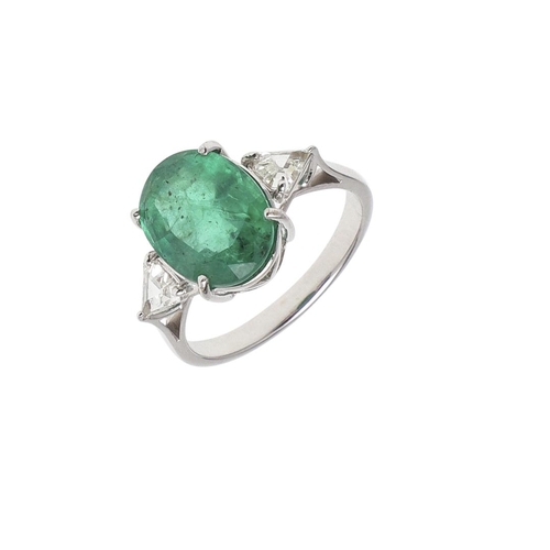 1135 - AN EMERALD AND DIAMOND THREE STONE RING. the oval-shaped emerald weighs 4.45 carats and is set with ... 