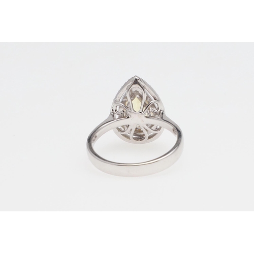 1136 - A GOLDEN BERYL AND DIAMOND CLUSTER RING. the pear-shaped beryl measures 1.34 carats and is set withi... 