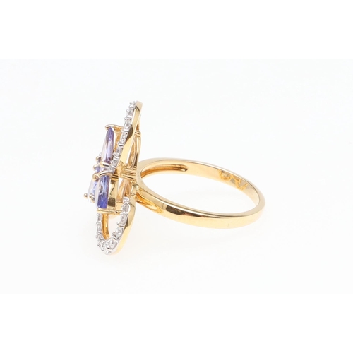 1137 - A TANZANITE AND DIAMOND COCKTAIL RING. centred with three pear-shaped tanzanites within a scrolling ... 