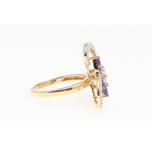 1137 - A TANZANITE AND DIAMOND COCKTAIL RING. centred with three pear-shaped tanzanites within a scrolling ... 