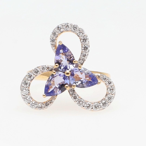 1137 - A TANZANITE AND DIAMOND COCKTAIL RING. centred with three pear-shaped tanzanites within a scrolling ... 