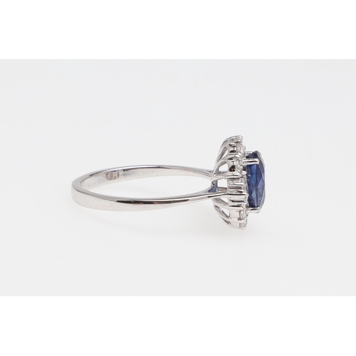 1138 - A SAPPHIRE AND DIAMOND CLUSTER RING. the oval-shaped sapphire weighs 2.34 carats and is set within a... 