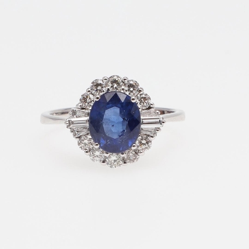 1138 - A SAPPHIRE AND DIAMOND CLUSTER RING. the oval-shaped sapphire weighs 2.34 carats and is set within a... 