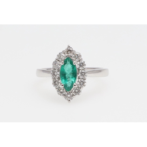 1140 - AN EMERALD AND DIAMOND CLUSTER RING. the marquise-shaped emerald is set within a surround of round b... 