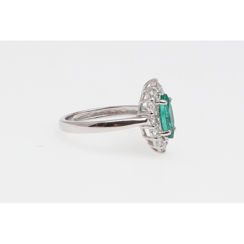 1140 - AN EMERALD AND DIAMOND CLUSTER RING. the marquise-shaped emerald is set within a surround of round b... 